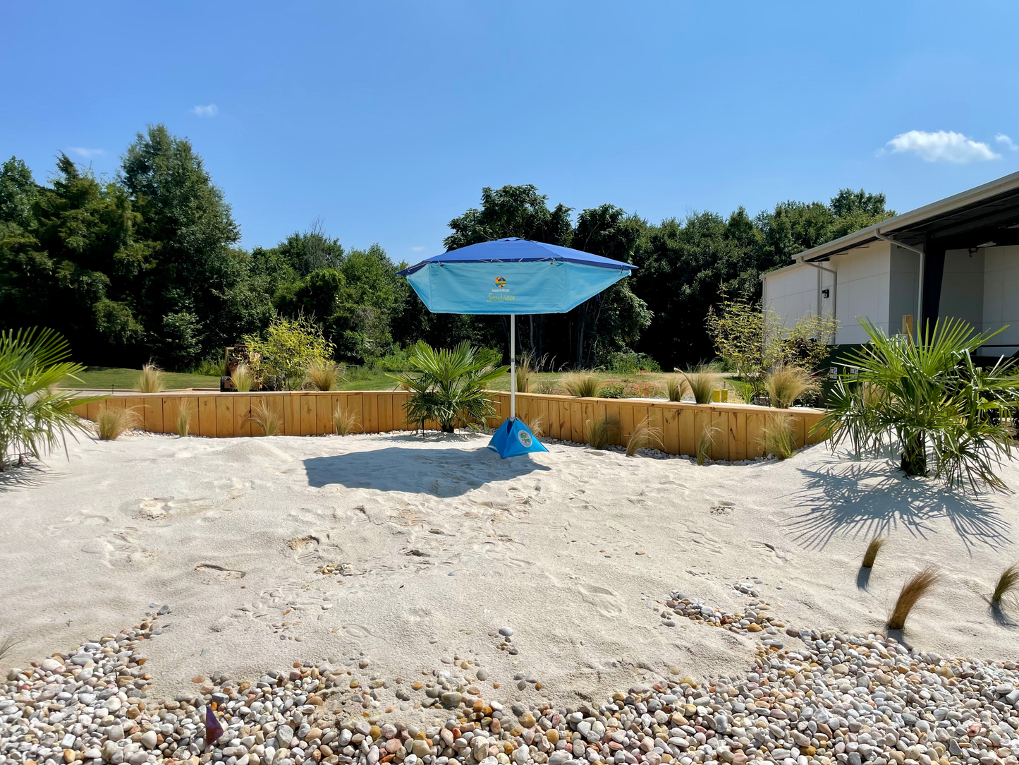beach umbrella with sunvisor addon set up outside in sandy beach area